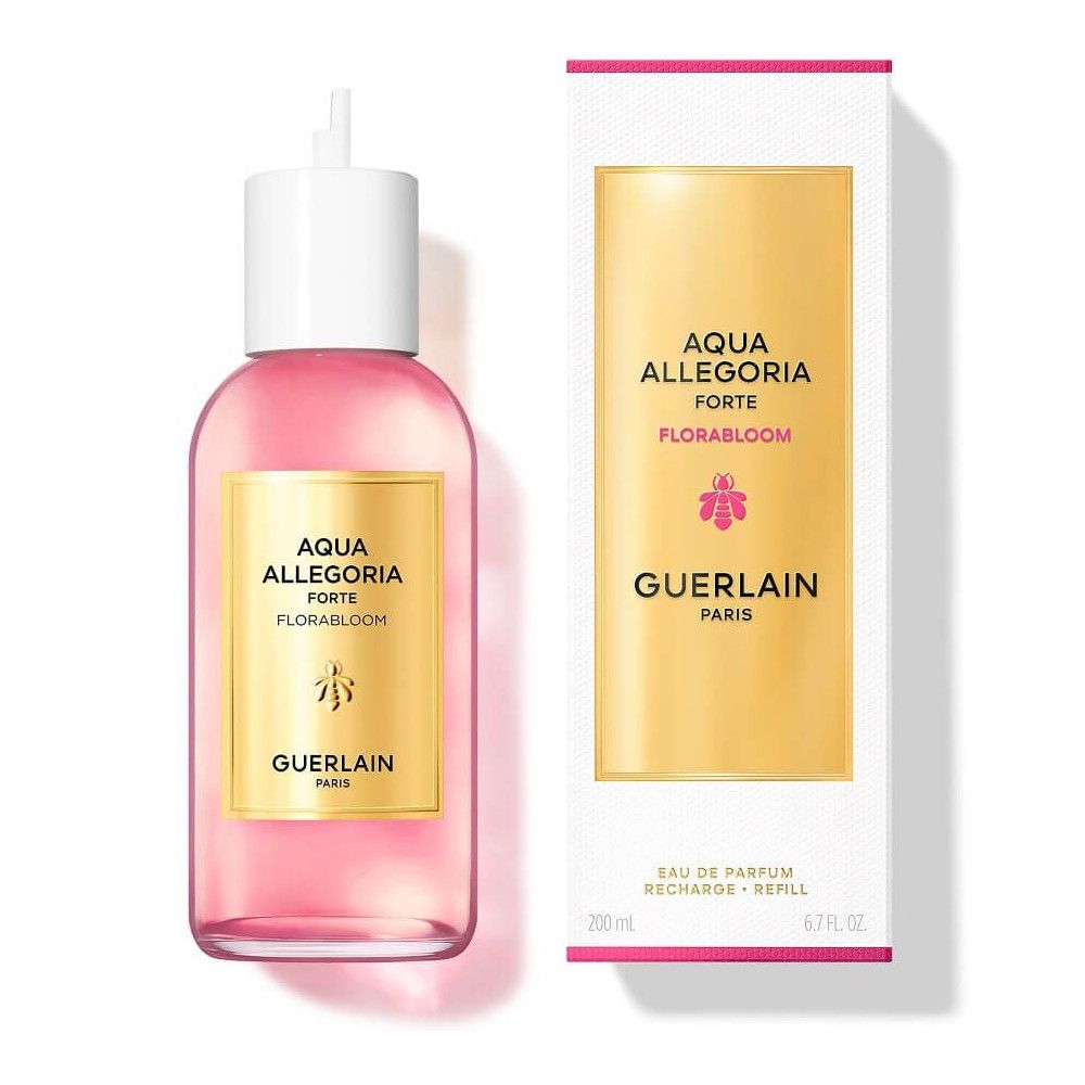 Rosa Flüssigkeit in Flasche mit weißem Verschluss, neben weißer Verpackung. Goldfarbenes Etikett mit Text: Aqua Allegoria Forte Florabloom, Guerlain Paris.
