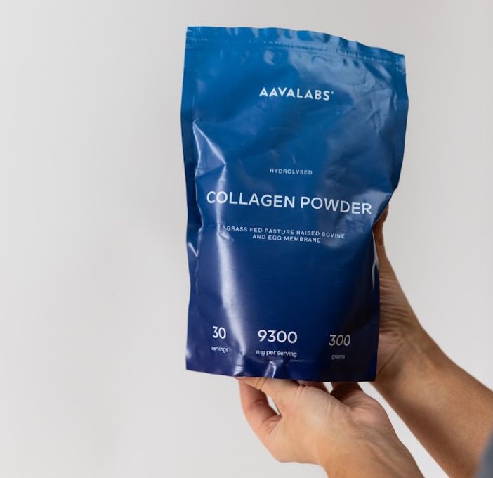 Hände halten einen blauen Beutel Kollagenpulver.