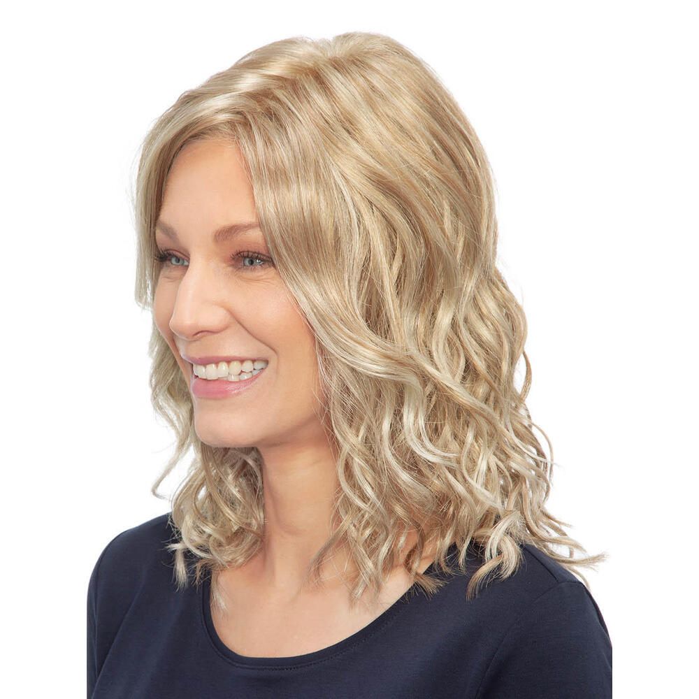 Blond gewellte Perücke. Seitenansicht einer Frau mit blonden, gewellten Haaren. Sie trägt ein dunkelblaues Oberteil.