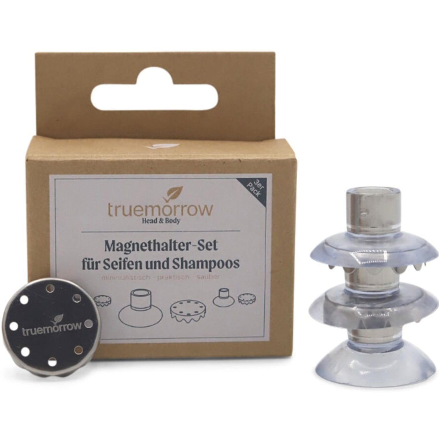 Produktverpackung mit Magnet-Seifenhalter-Set. Enthält Halterung, runde Metallplatte und Saugnapf-Halterung. Text: truemorrow.