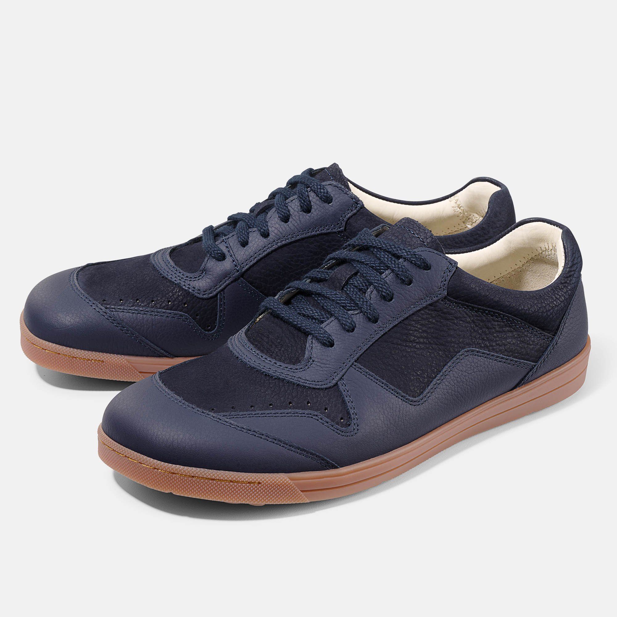 Zwei blaue Schnürschuhe mit brauner Sohle. Obermaterial aus Leder und Textil. Perforierte Details an der Zehenkappe.