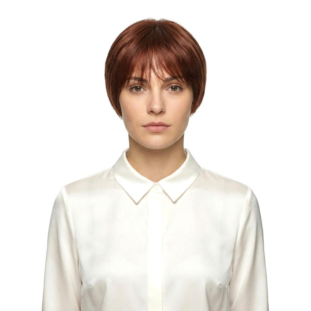 Kurzhaarperücke in Rotbraun mit Pony. Frontale Ansicht einer Frau mit weißem Hemd.
