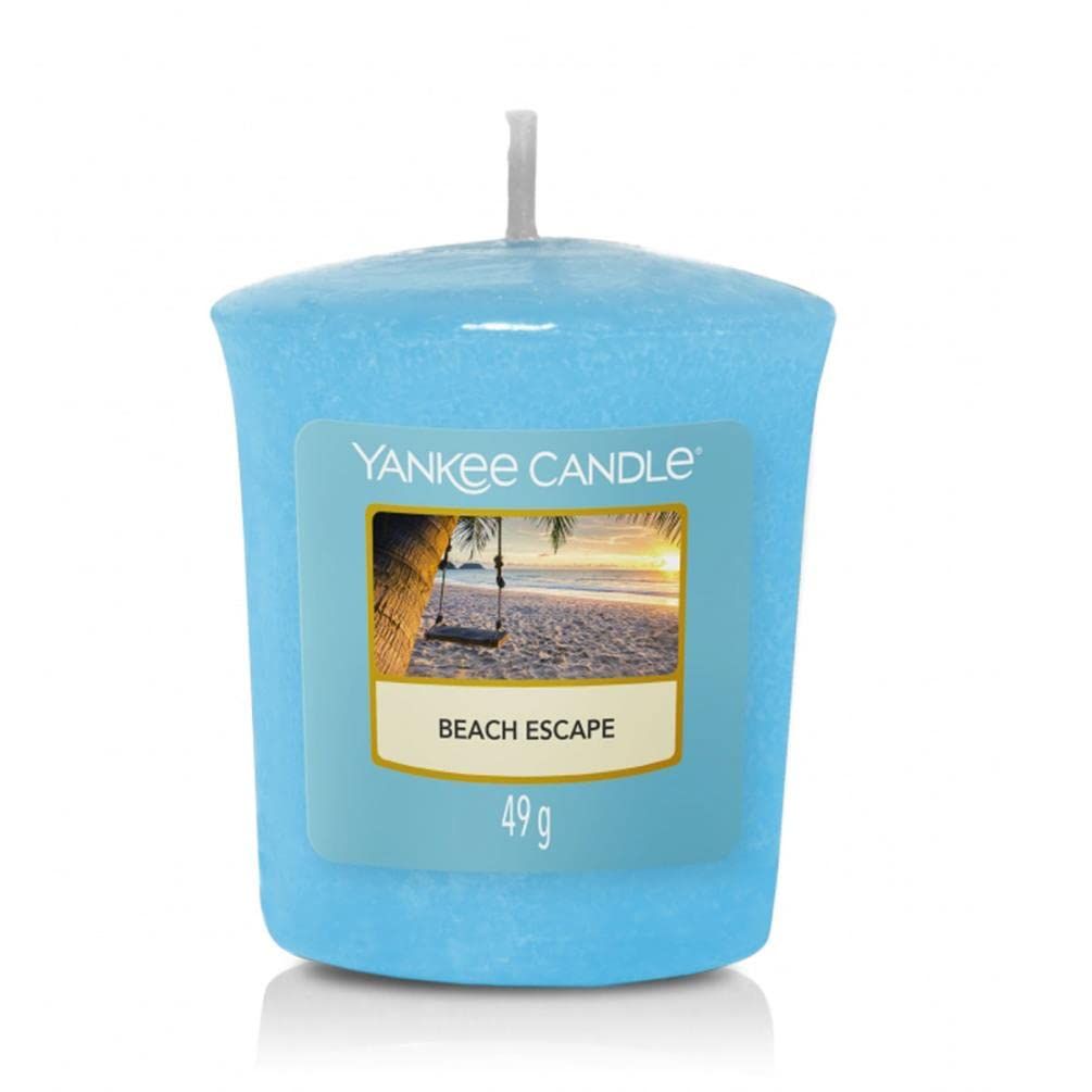 Hellblaue Kerze mit Etikett. Aufschrift: Yankee Candle, Beach Escape, 49 g. Abbildung: Strand mit Schaukel.