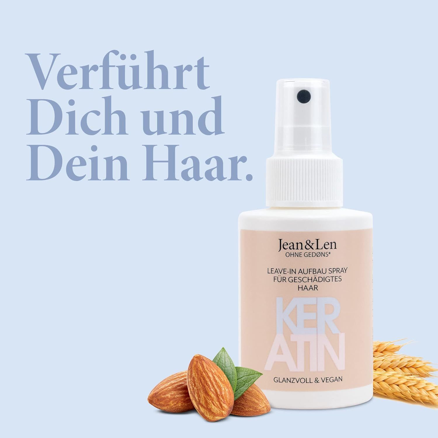 Weiße Sprühflasche mit rosa Etikett. Text: Jean & Len, Leave-In Aufbauspray Keratin. Mandeln und Ähren liegen vor der Flasche. Vegan-Siegel.