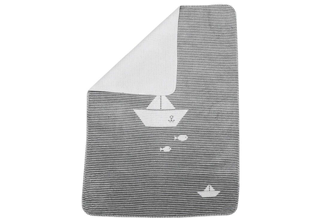 Gestreifte Decke mit Segelboot-Motiv. Die weiße Innenseite der Decke ist sichtbar.