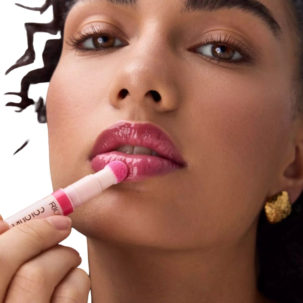 Ein Lippenstiftapplikator mit rosa Schwammspitze, der auf die Lippen aufgetragen wird.