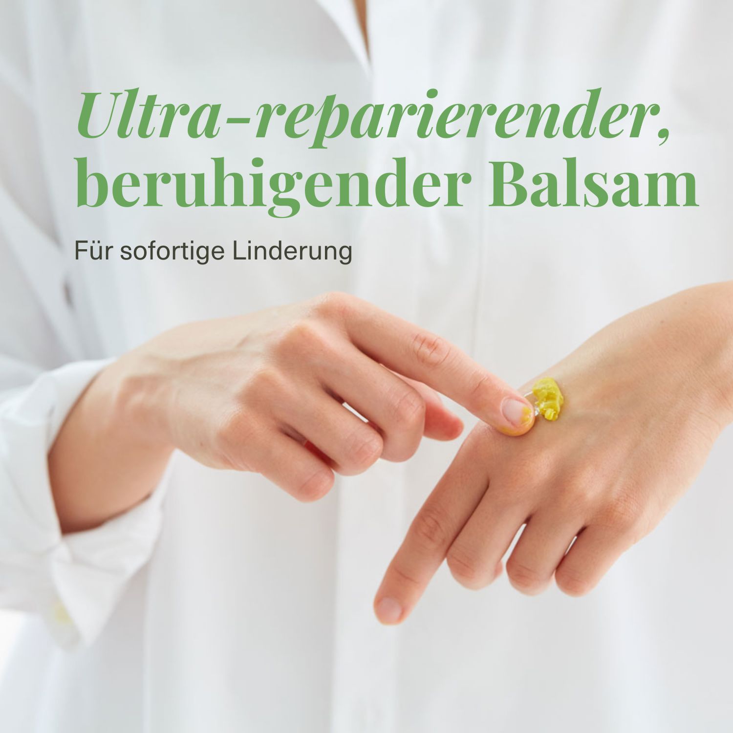 Hände verreiben gelbe Salbe auf dem Handrücken. "Ultra-reparierender, beruhigender Balsam."