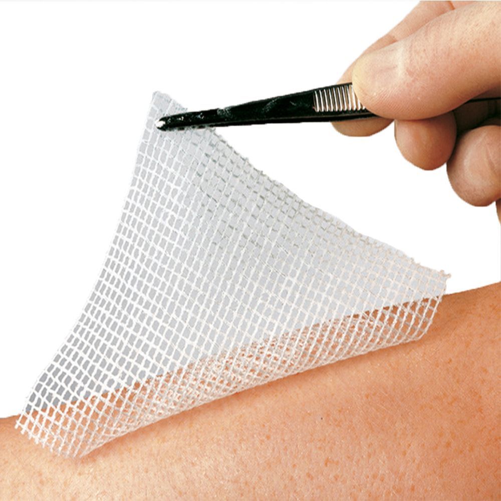 Weißes, quadratisches Netzgewebe wird mit einer Pinzette auf einem Arm gehalten. Das Gewebe ist auf der Haut platziert.