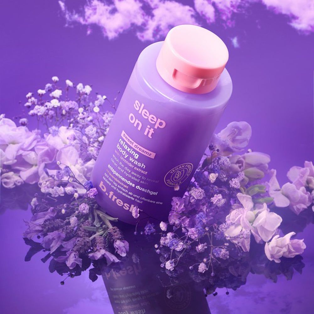 Lila Flasche mit "sleep on it" entspannendem Duschgel, umgeben von lila und weißen Blumen.