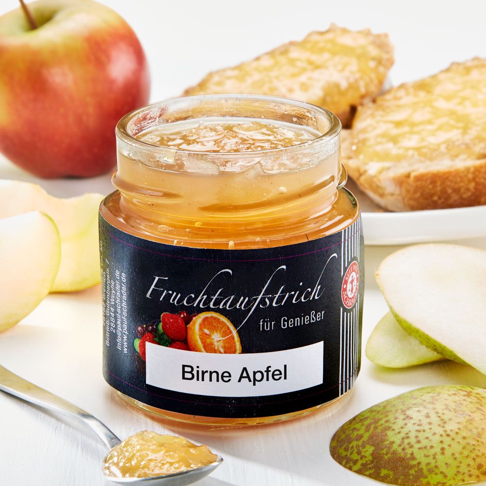 Glas Schrader Fruchtaufstrich Birne-Apfel. Etikett mit Früchten. Apfel, Birne und Brotstücke daneben.