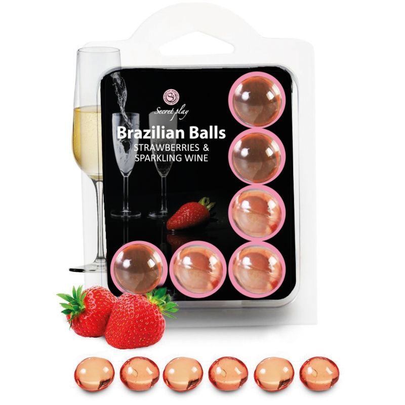 Verpackung mit acht rosafarbenen Kugeln, Erdbeeren und Sektgläsern.