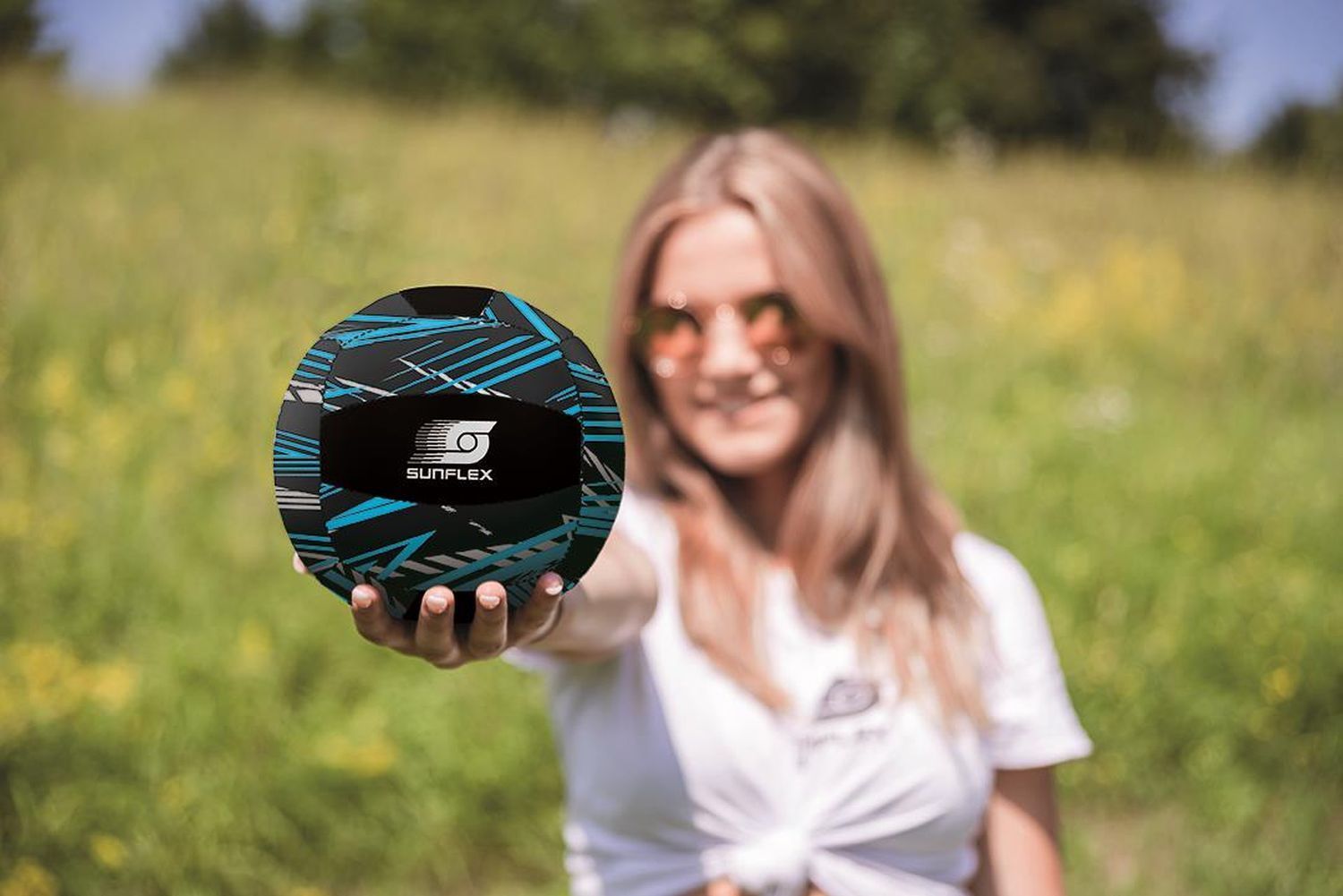 Frau hält einen blau-schwarzen Ball mit SUNFLEX-Logo in der Hand.