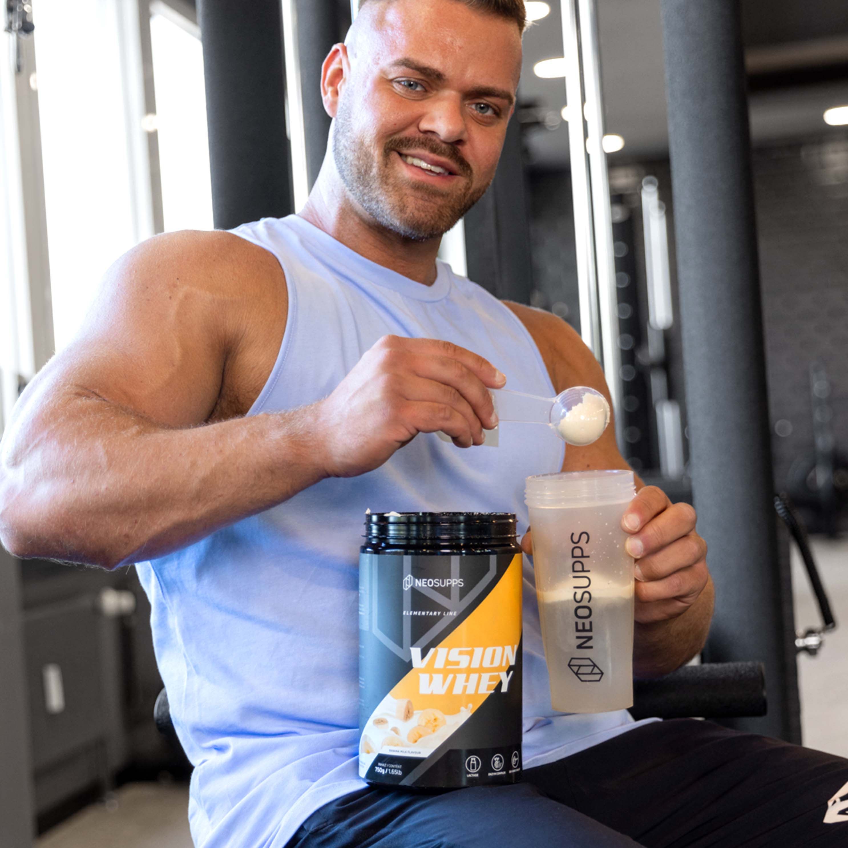 Mann hält Shaker und Dose Vision Whey. Dose mit gelbem Akzent. Text: Vision Whey, Neosupps.
