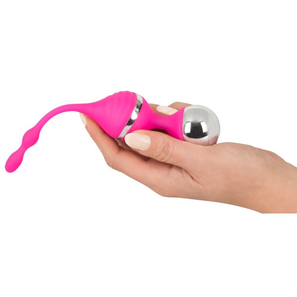Rosa Vibrationskugel, gehalten in einer Hand. Silberne Akzente und eine längliche Form mit drei Kugeln.