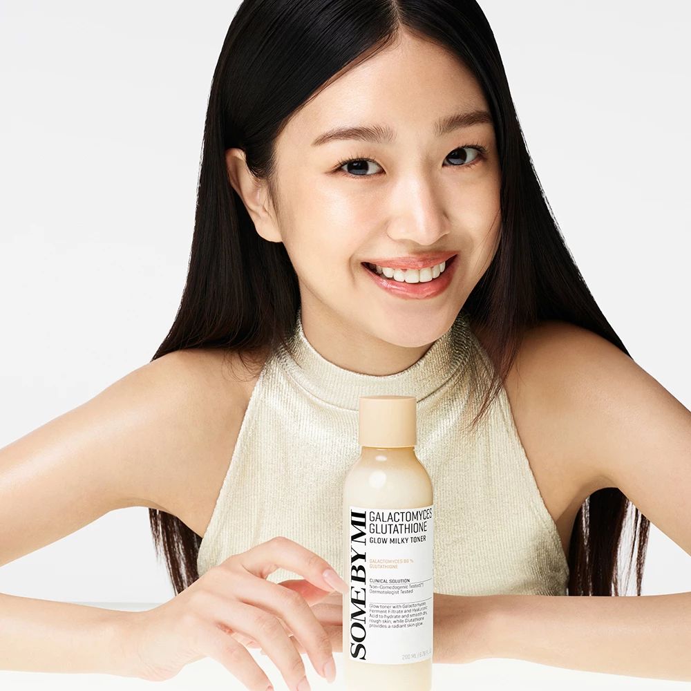 Frau hält Flasche SOME BY MI, Galactomyces Glutathione Glow Milky Toner. Frau lächelt.