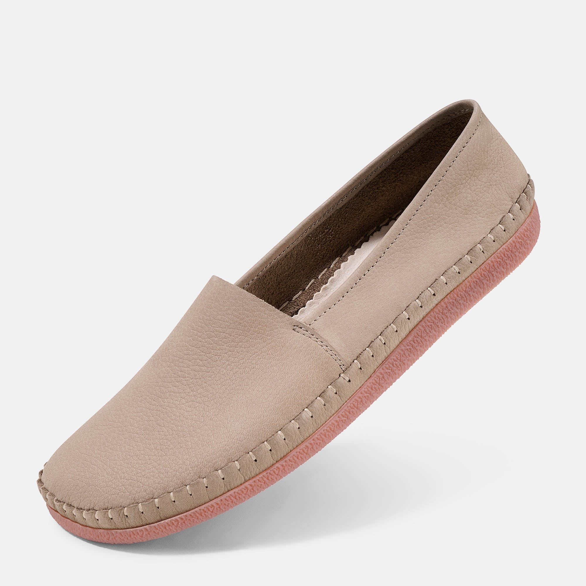 Beigefarbener Slipper mit rosafarbener Sohle. Sichtbare Nähte. Flache Form.