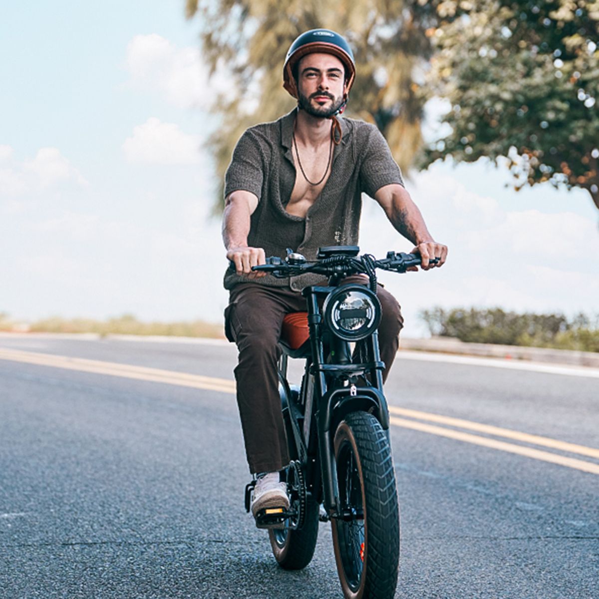 Mann fährt auf einem schwarzen Elektrofahrrad. Er trägt einen Helm und ein Hemd.