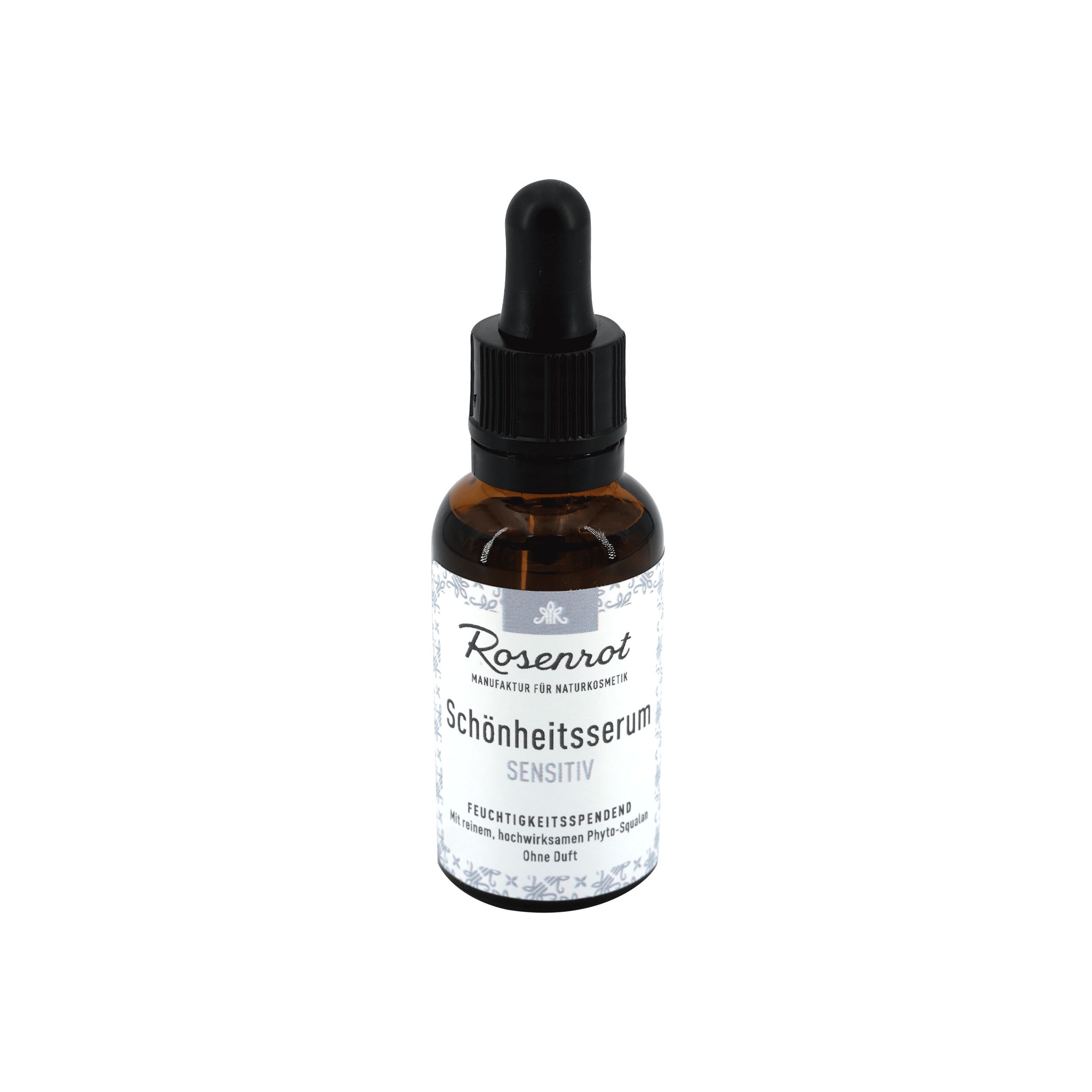 Braune Glasflasche mit schwarzem Deckel und Pipette. Etikett mit Produktnamen und Text. "Schönheitsserum Sensitiv".