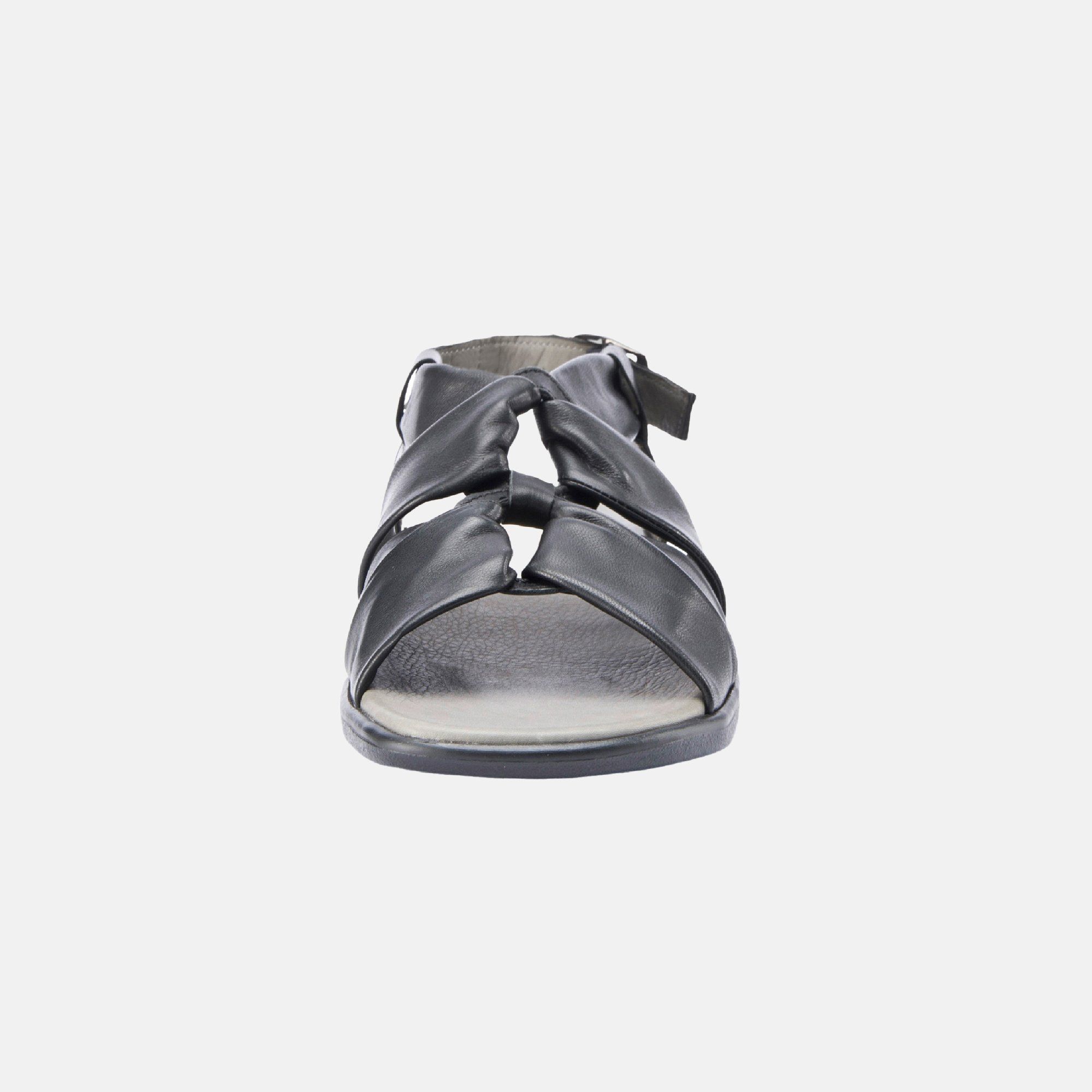 Schwarze Sandale, Frontansicht. Breiter Riemen, offene Zehenpartie, verstellbarer Riemen. Graue Innensohle.