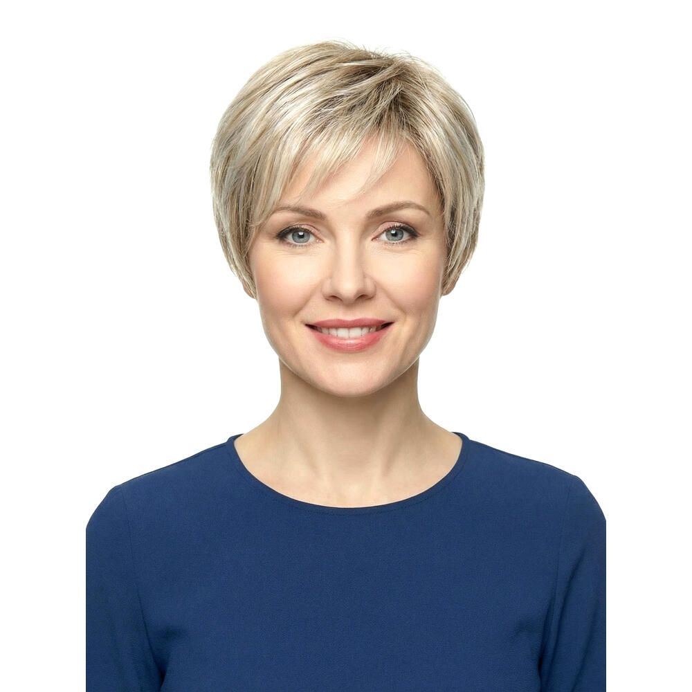 Kurzhaarperücke in Blondtönen. Frontale Ansicht einer Frau mit blauem Oberteil. Sie lächelt.