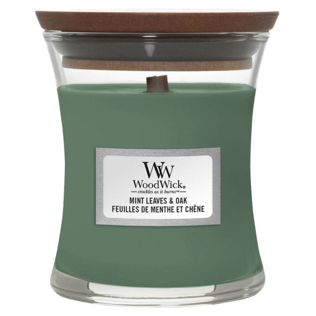 Grüne Kerze in Sanduhrform mit Holzdeckel. Aufkleber mit Produktnamen und Marke WoodWick. Mint Leaves & Oak.