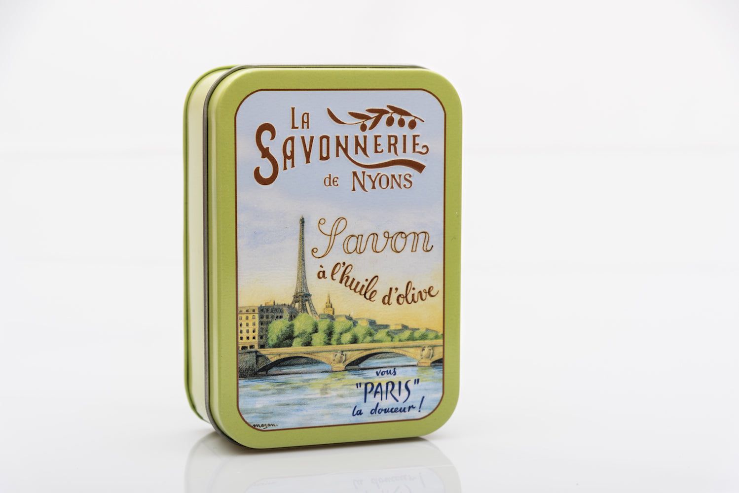 Grüne Metallbox mit Seife. Aufdruck "La Savonnerie de Nyons", Eiffelturm-Motiv und Schriftzug "Savon à l'huile d'olive".