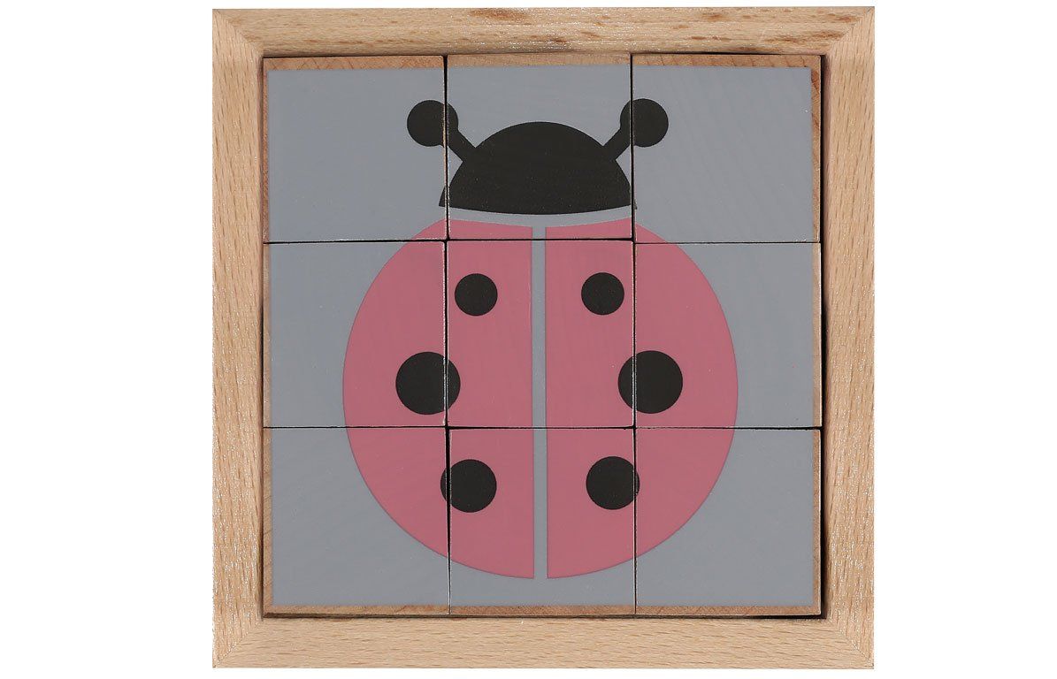 Holzwürfel-Puzzle mit Marienkäfer-Motiv. Neun Würfel bilden ein Bild in einem Holzrahmen. Rosa, grau und schwarz.