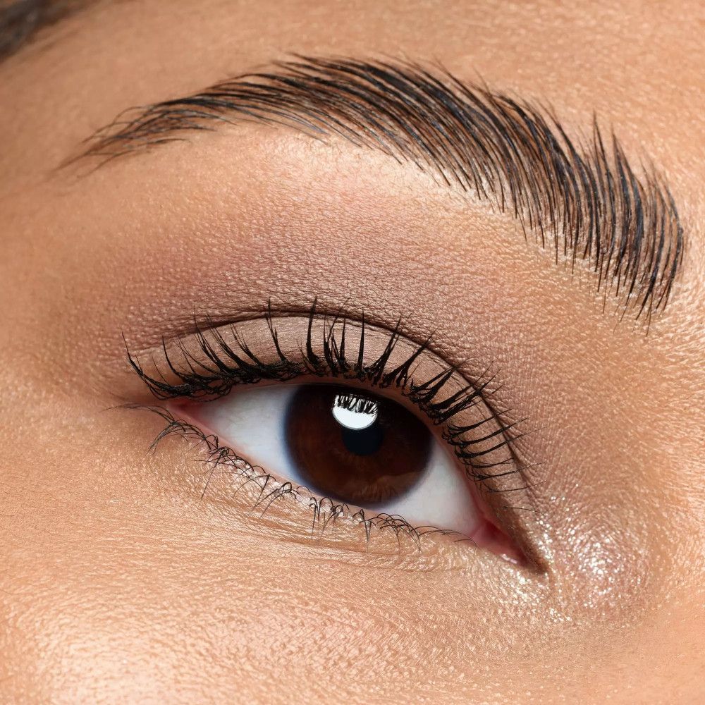 Nahaufnahme eines Auges mit geschminkten Lidern. Der Lidschatten ist in Brauntönen gehalten.