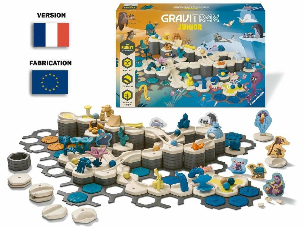 Ravensburger GraviTrax Junior Starter-Set XXL Planet, un gioco di costruzioni di piste per biglie. L'immagine mostra il gioco con vari elementi e la confezione. Include bandiere francese ed europea.