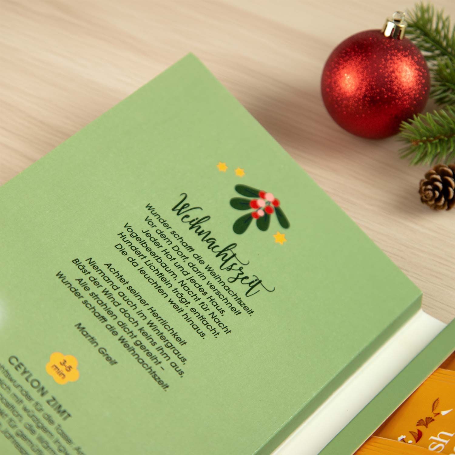 Geöffnete Geschenkbox mit Text und weihnachtlichen Illustrationen. Text: Weihnachtszeit. Ceylon Zimt.