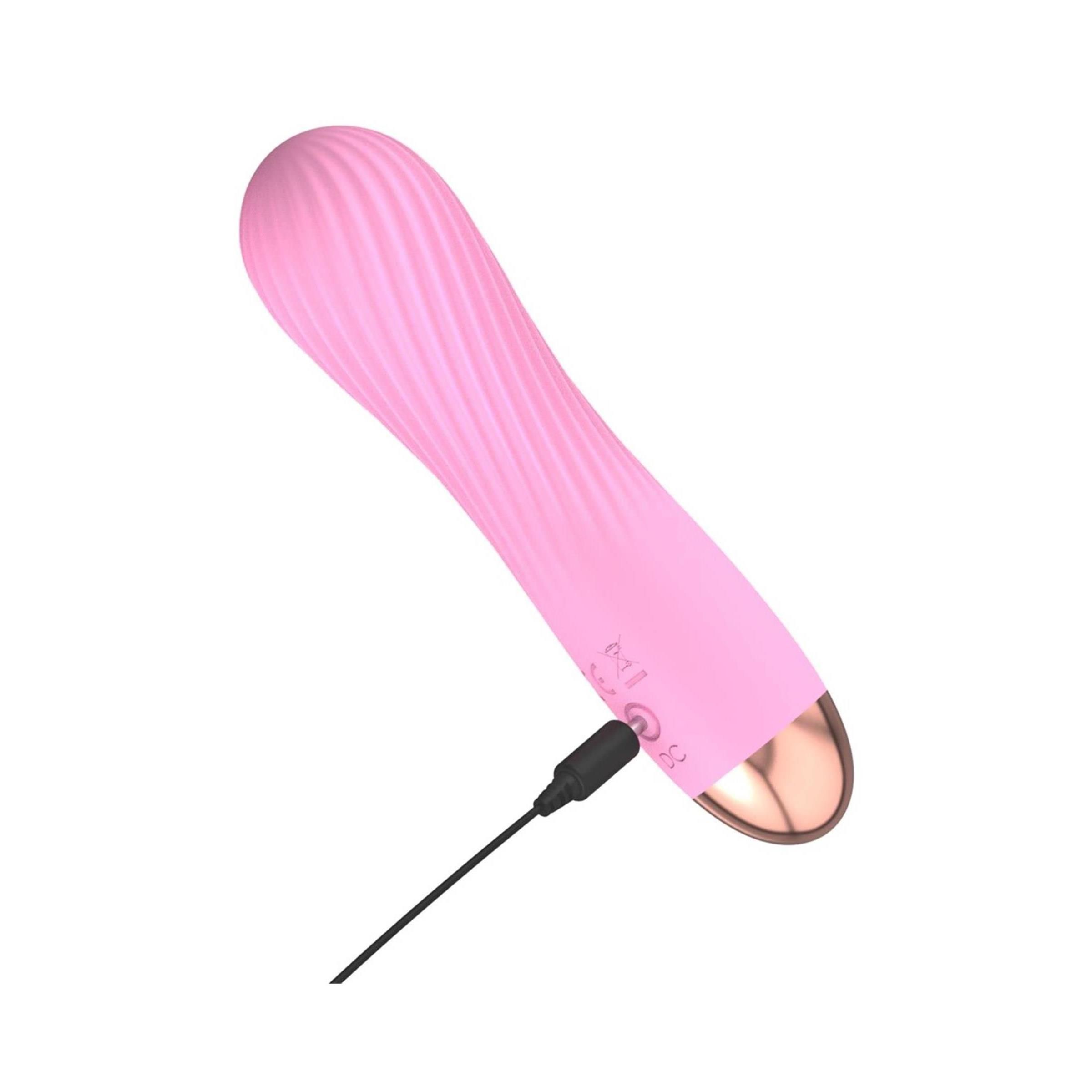 Rosa Vibrator mit Ladekabel. Goldfarbene Spitze, gewellte Oberfläche.