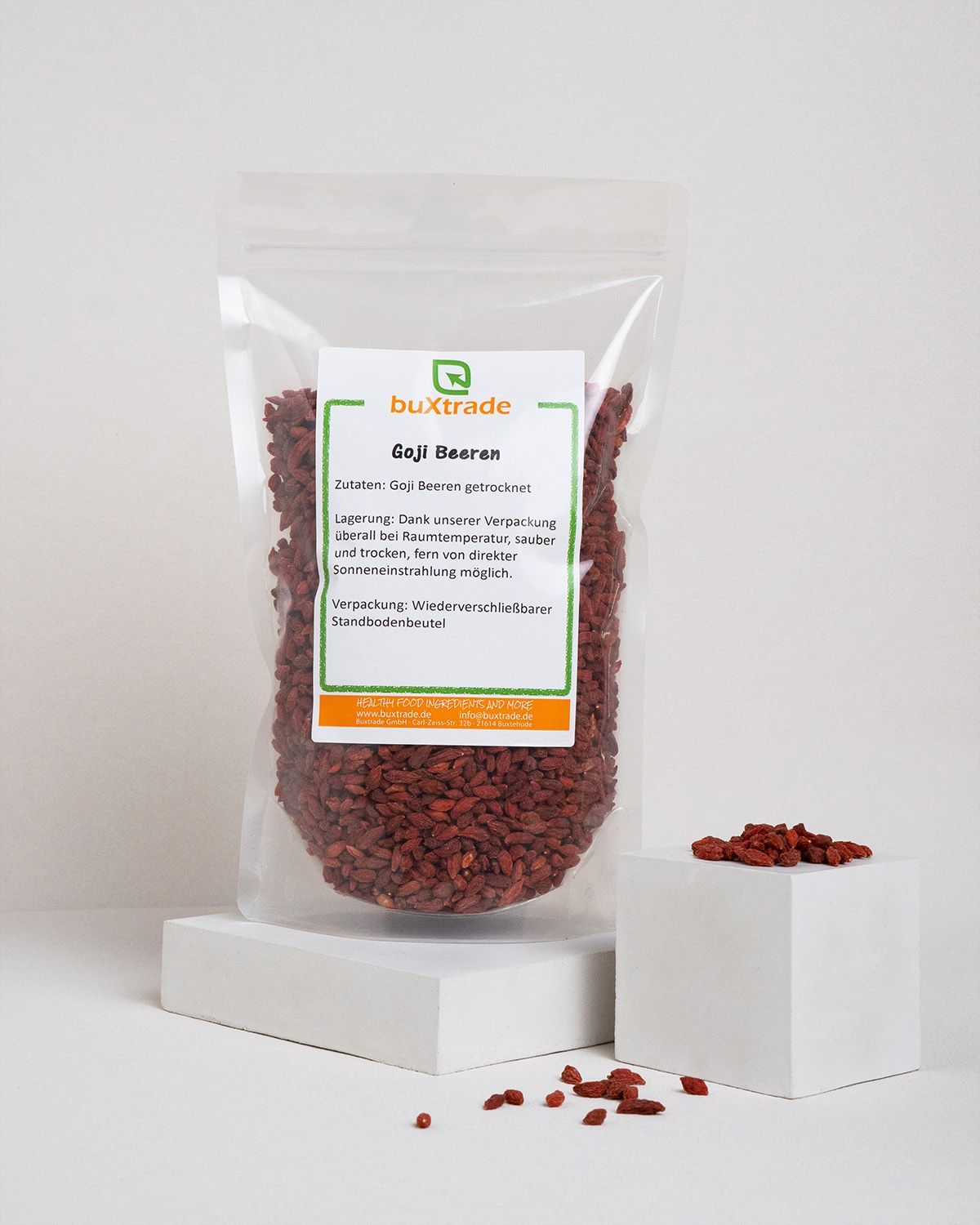 Verpackung von buXtrade Goji Beeren. Transparenter Beutel mit Etikett auf weißem Podest.