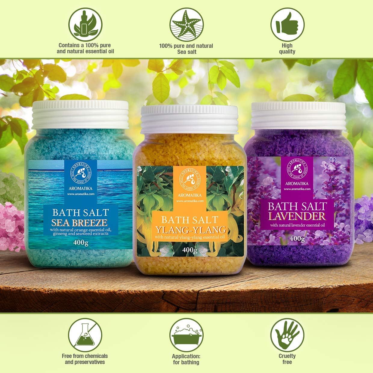 Drei Gläser Badesalz. Gelb, blau und lila. Etiketten mit Produktnamen und Logo. Gelb: Ylang-Ylang. Blau: Meeresbrise. Lila: Lavendel. Symbole für Qualität.