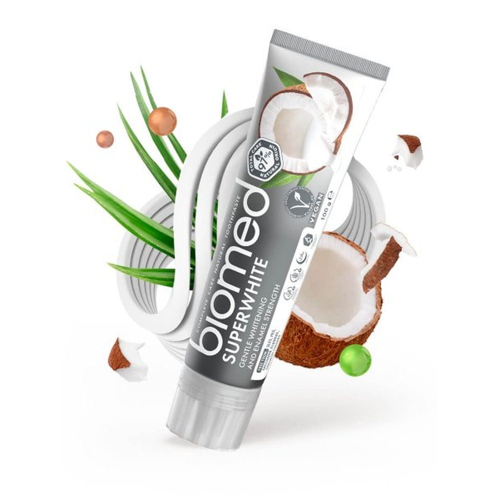 Zahnpasta-Tube mit Kokosnuss-Motiv. Marke: biomed Superwhite. Text: Gentle Whitening and Enamel Strength. Vegan. Dekoration.