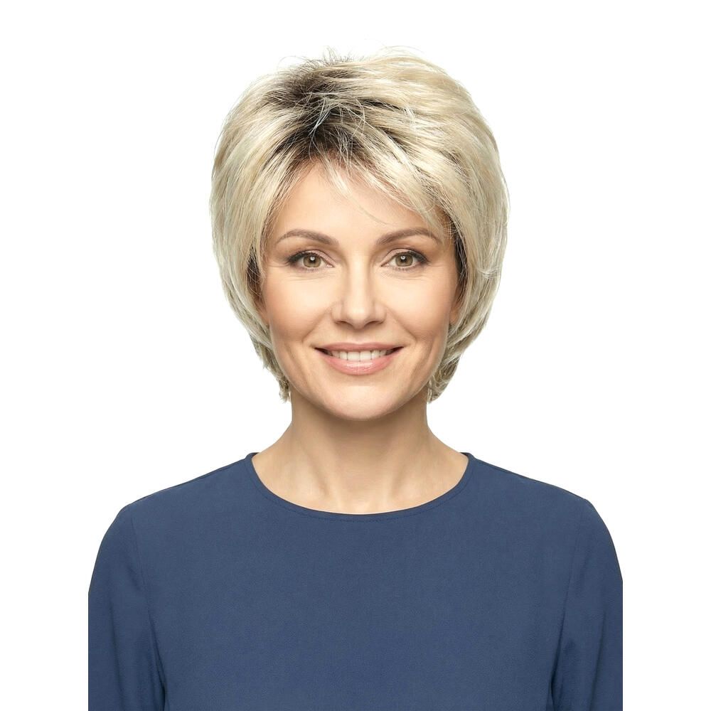 Blond gefärbte Perücke mit kurzem, gestuftem Schnitt. Die Frau trägt ein blaues Oberteil. Frontansicht.