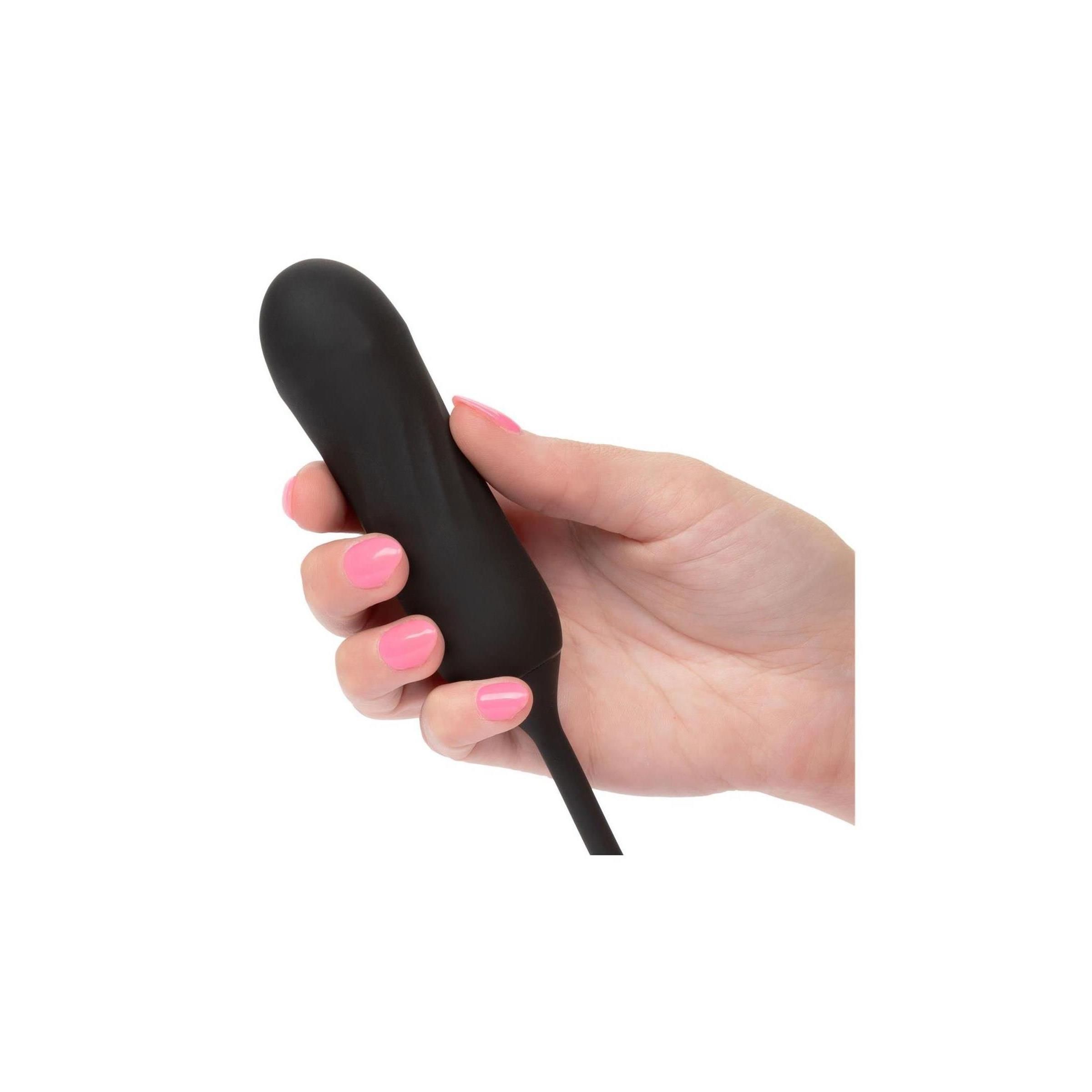 Schwarzes Wellness-Produkt in Hand. Abgebildet: Vibrator. Rosa lackierte Fingernägel.