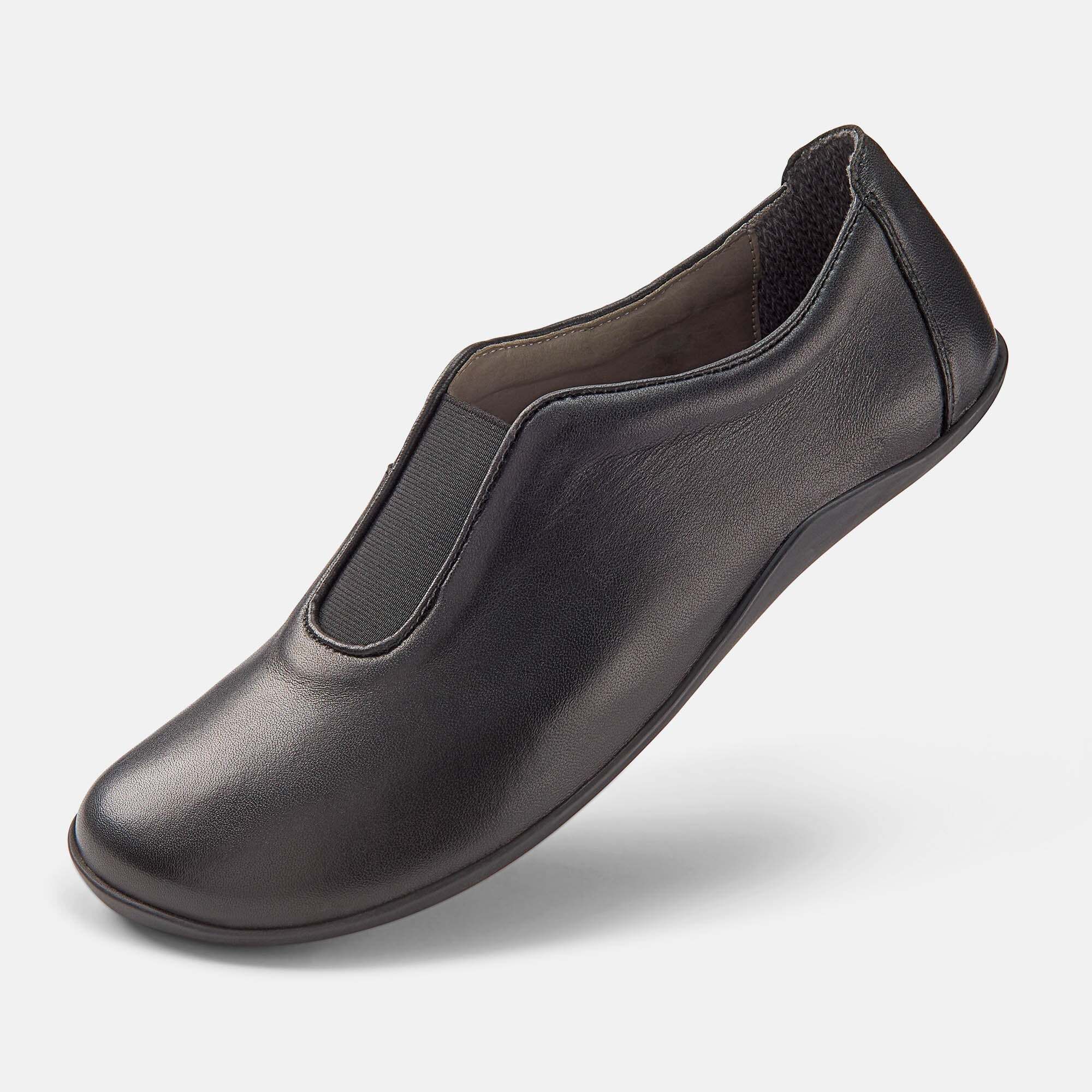 Schwarzer Damen-Slipper aus Leder, Seitenansicht, mit elastischem Einsatz und flacher Sohle.