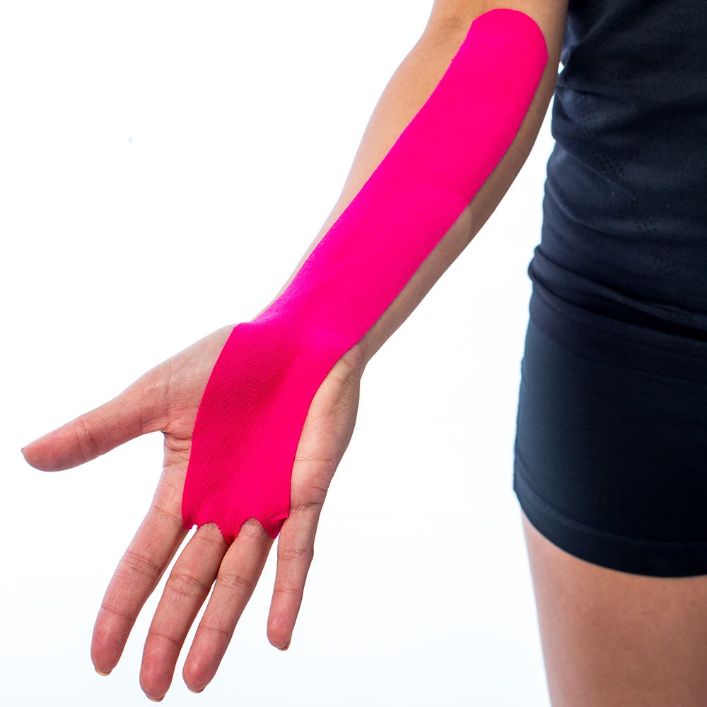 Rosa Kinesiotape auf dem Arm einer Person. Tape bedeckt den Unterarm und die Handfläche.