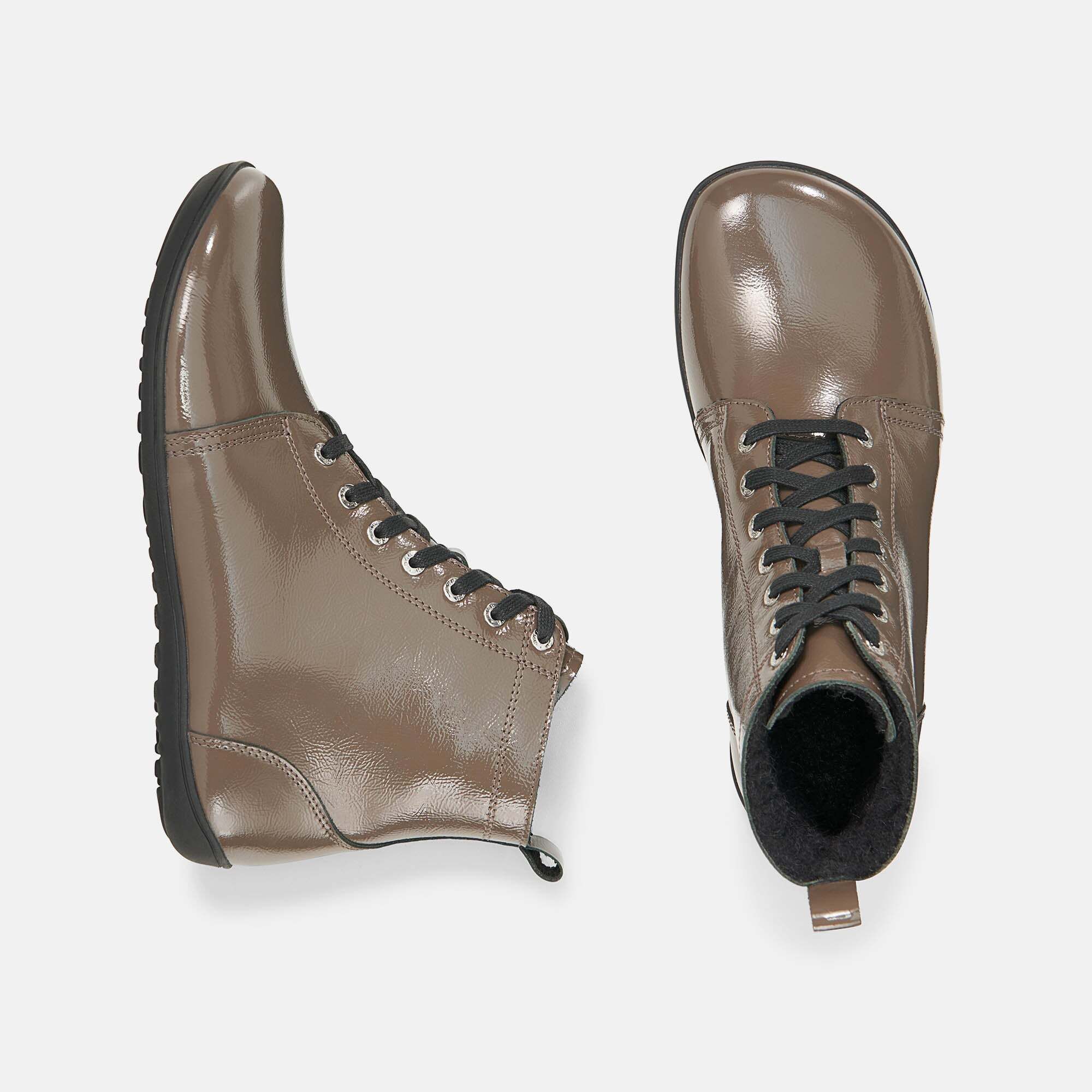 Zwei braune Stiefeletten von oben. Schwarze Sohlen, Schnürsenkel und Innenfutter. Glänzendes Obermaterial.