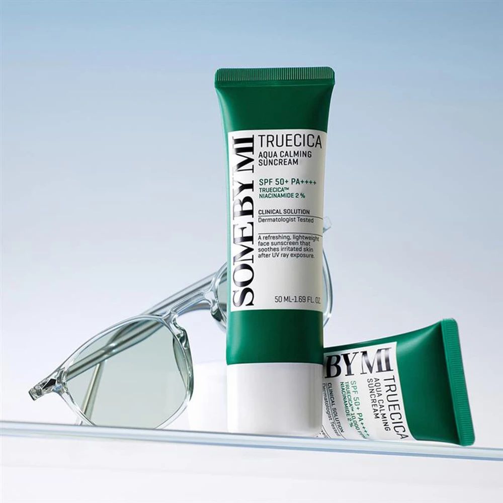 Zwei grüne und weiße Tuben Sonnencreme. Text: SOMEBYMI, Truecica Aqua Calming Suncream, SPF 50+ PA++++. Brille daneben.