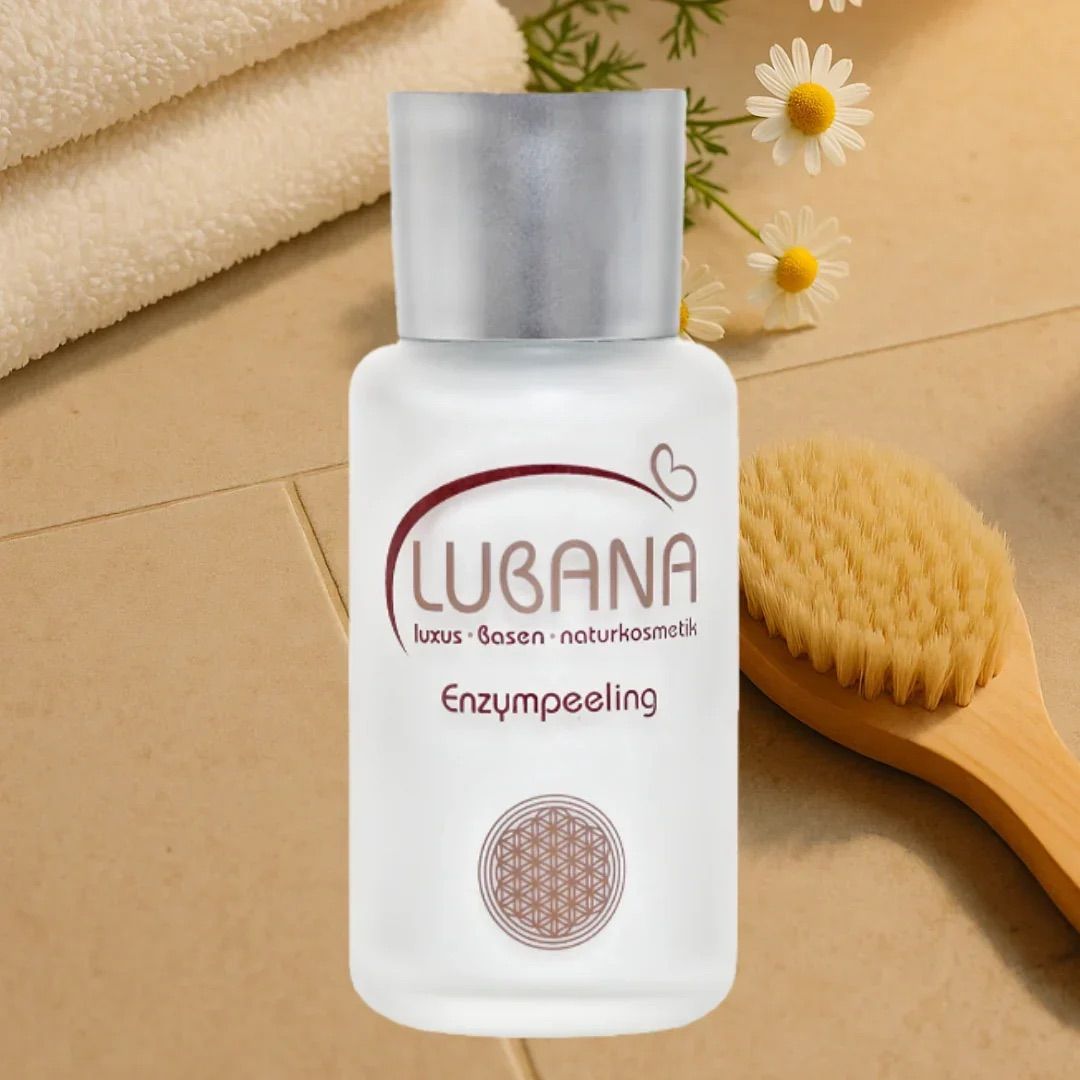 Weißes Fläschchen mit silbernem Deckel, neben einer Bürste und Handtüchern. Aufschrift: LUBANA, Enzympeeling.