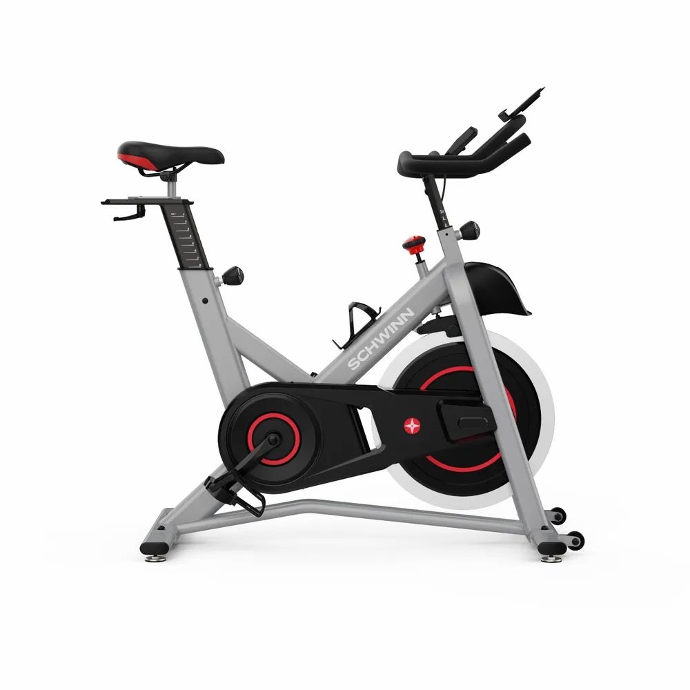 Grauer Heimtrainer mit rotem Akzent. Schwarzes Schwungrad, Lenker, Sattel und Pedale. Marke: Schwinn.