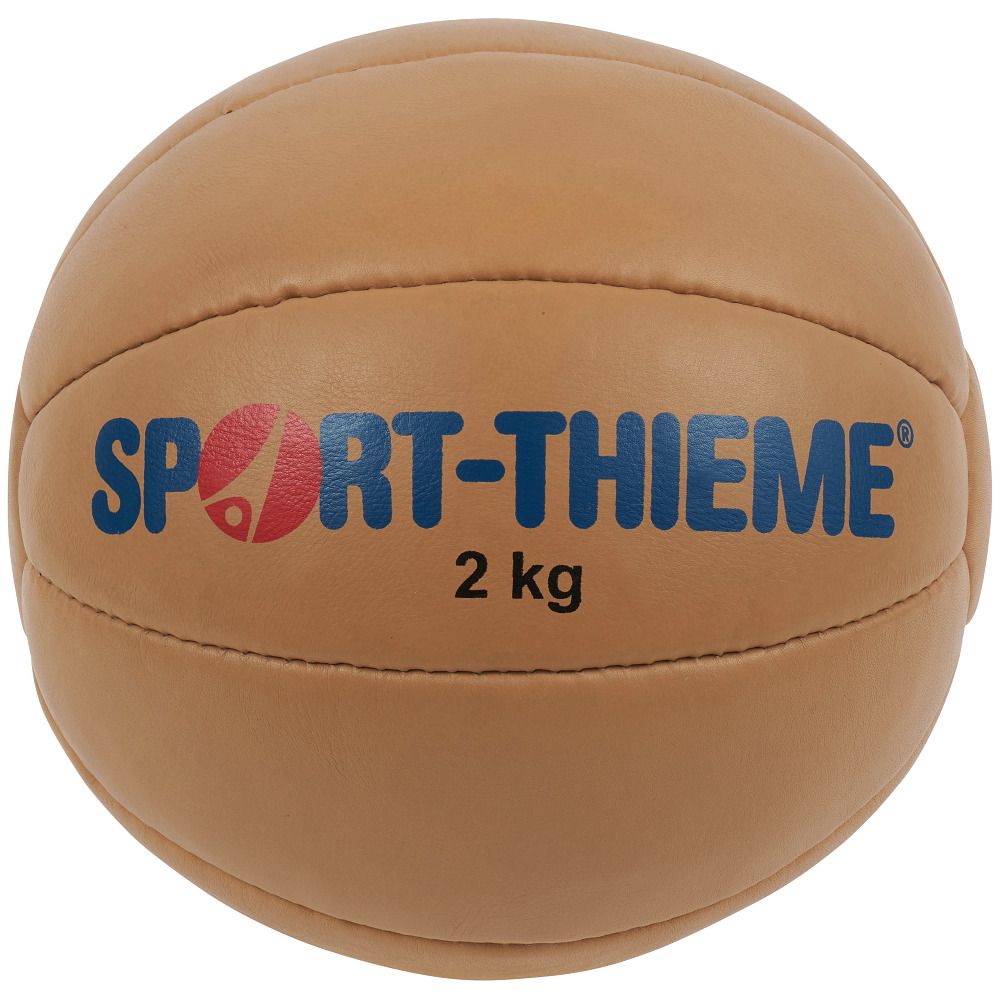 Beigefarbener Medizinball. Aufschrift: SPORT-THIEME, 2 kg. Lederoptik mit Nähten.