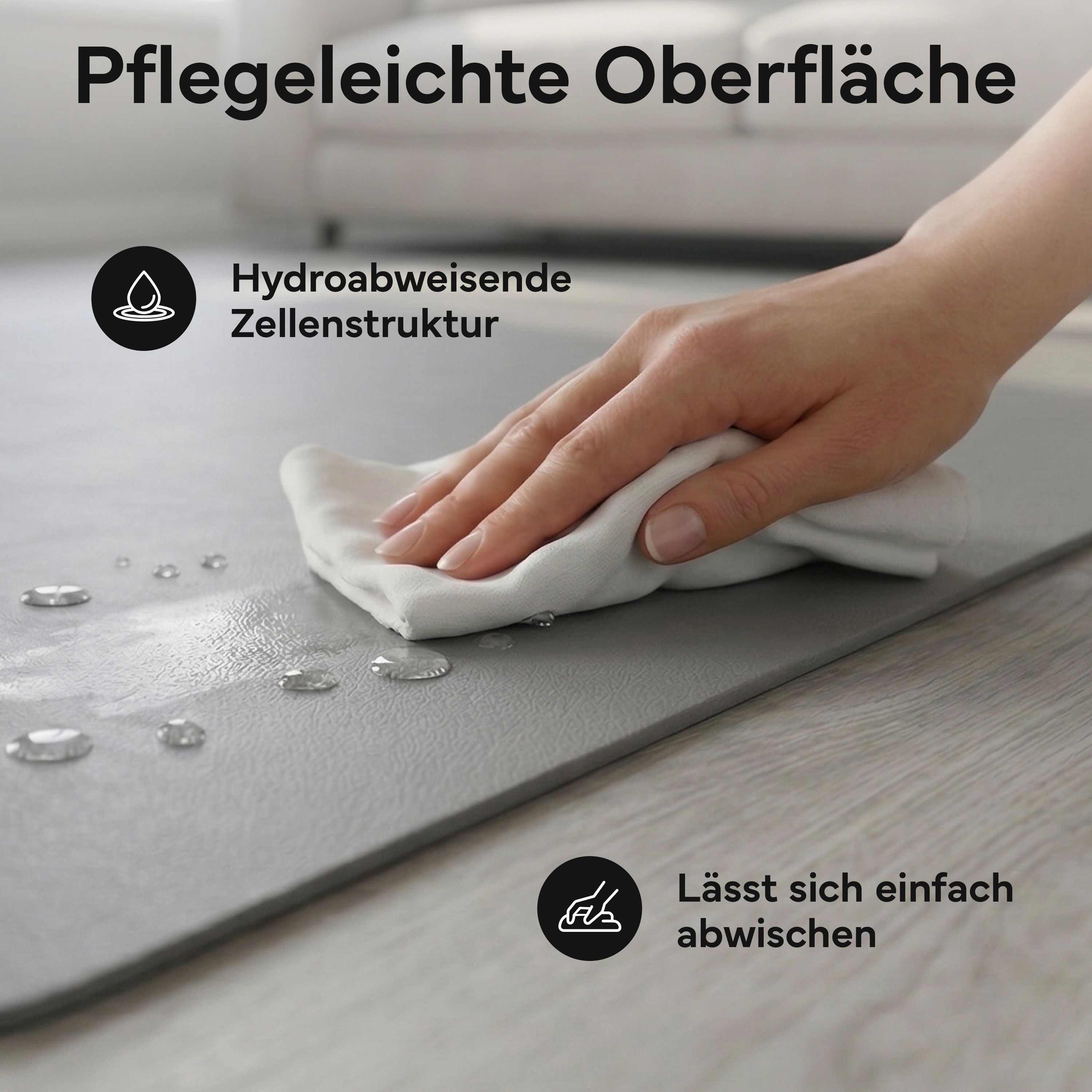Hand wischt Wasser von der grauen Fitnessmatte ab. Die Oberfläche ist wasserabweisend und hat eine Zellstruktur. Lässt sich leicht abwischen.