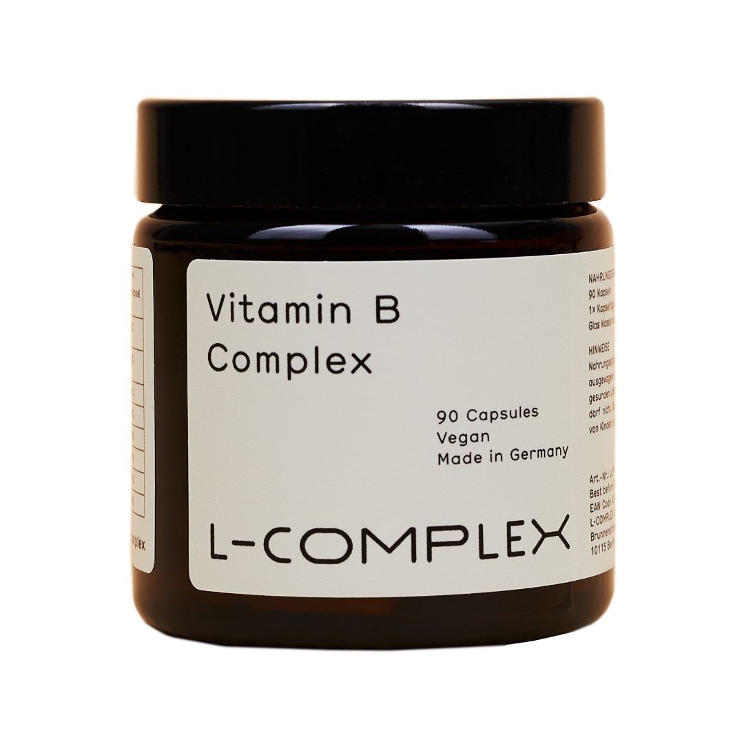Braune Glasdose mit schwarzem Deckel. Etikett mit "Vitamin B Complex", "90 Capsules", "Vegan", "L-COMPLEX".