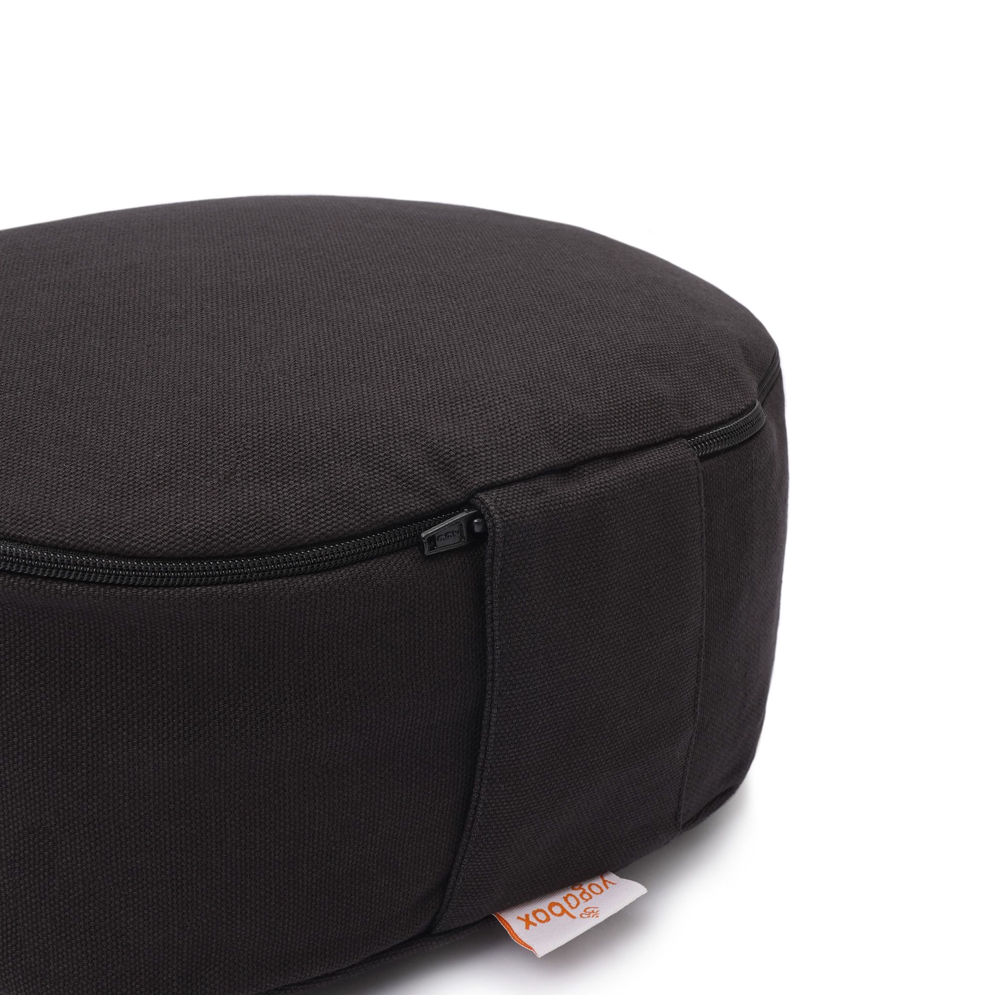 Detailansicht eines schwarzen Meditationskissens mit Reißverschluss und Yogabox-Label.