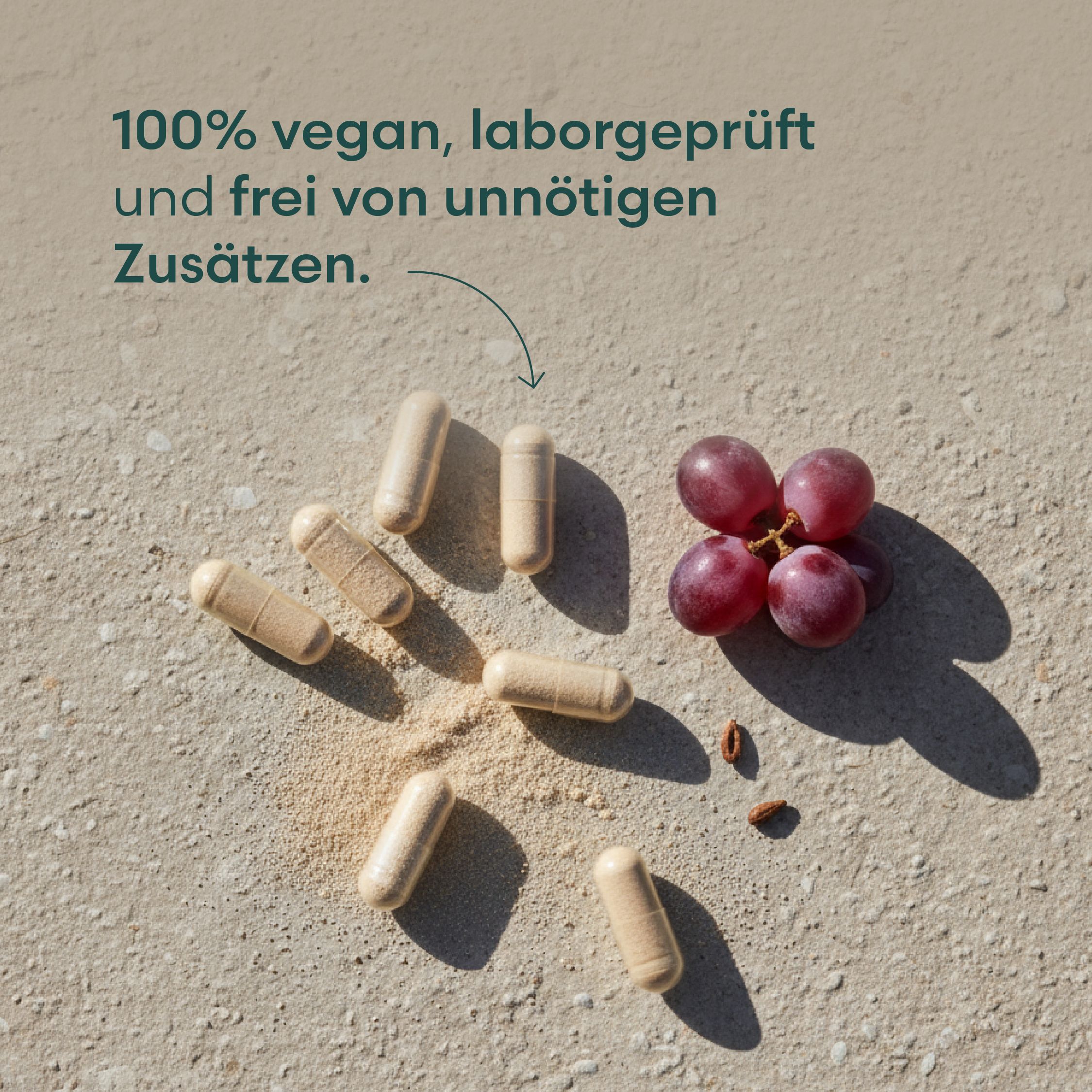 Kapseln und Trauben auf rauer Oberfläche. Text: 100% vegan, laborgeprüft und frei von unnötigen Zusätzen.
