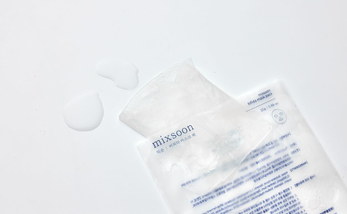 Geöffnete Maskenpackung mit ausgelaufener Flüssigkeit. Aufdruck: mixsoon, Bifida Mask Pack. Weißer Hintergrund.