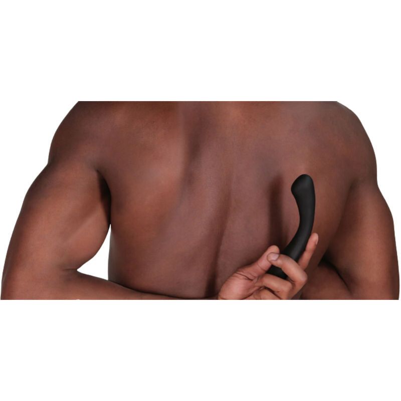 Schwarzer Vibrator, gebogene Form, in der Hand einer Person. Person von hinten gezeigt.