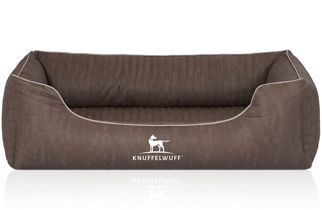 Braunes orthopädisches Hundebett mit weißem Rand und Logo. Rechteckige Form mit erhöhten Seiten. Gepolsterte Oberfläche.
